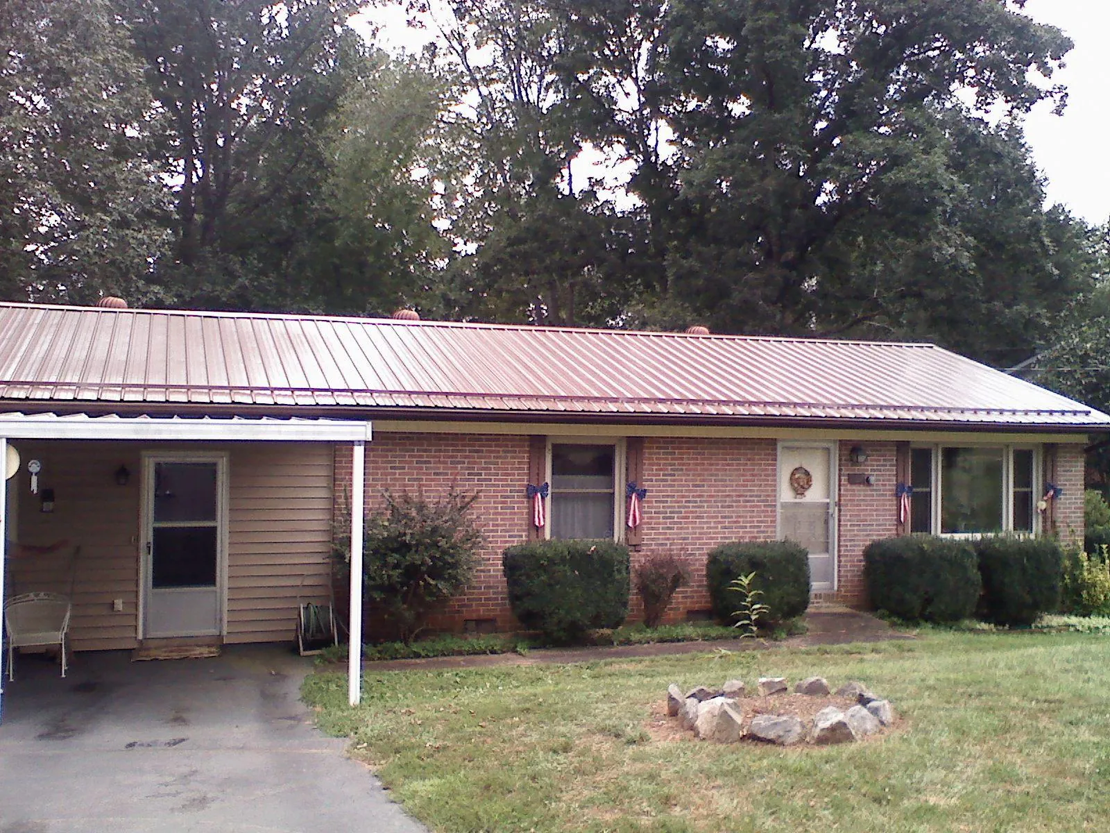 Bronze metal roof and carport on a brick ranch home — Roof Repair work by our crew in Henderson